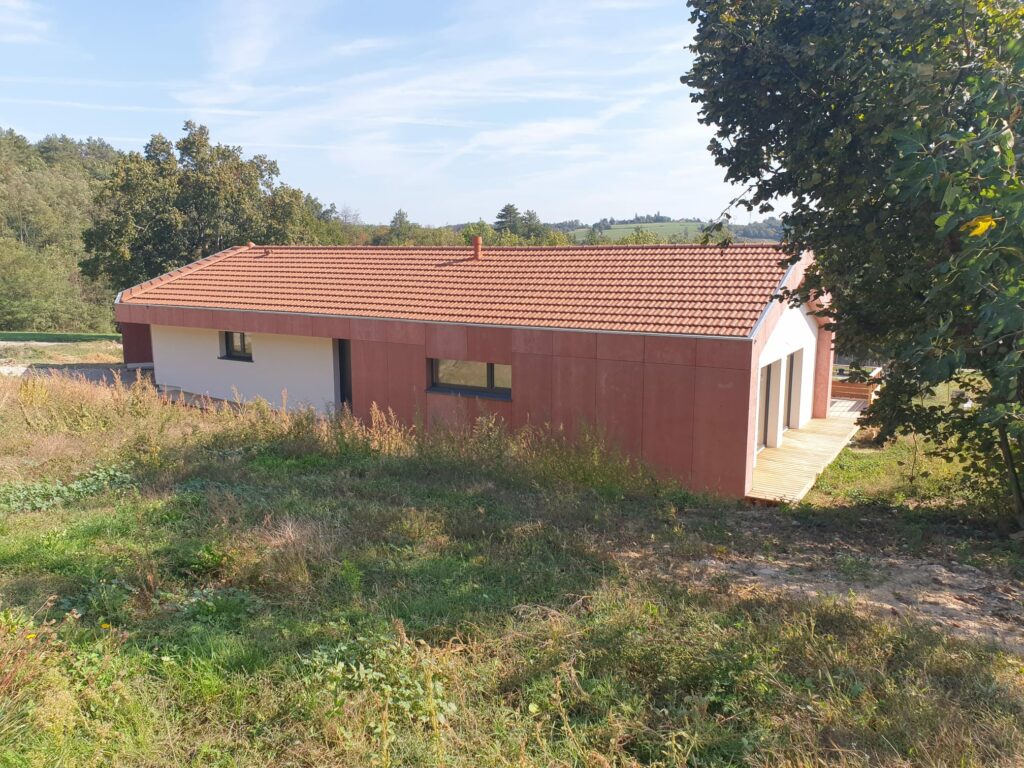 Vue d’une maison passive contemporaine avec bardage Viroc rouge