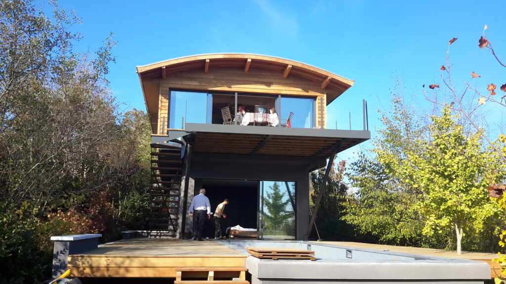 Extension contemporaine en ossature bois avec terrasse et grandes ouvertures.