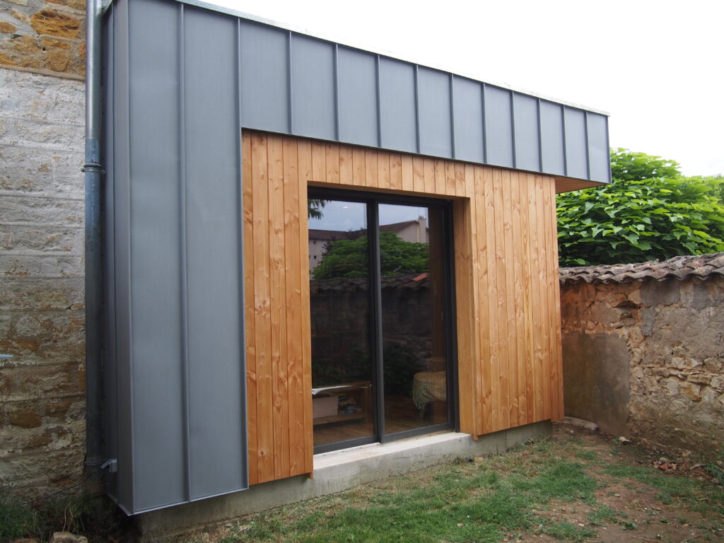 Extension contemporaine avec toiture plate et grande baie vitrée.