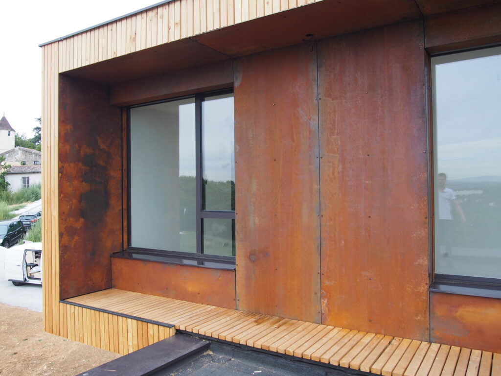 Maison contemporaine en ossature bois avec bardage en mélèze et acier corten.