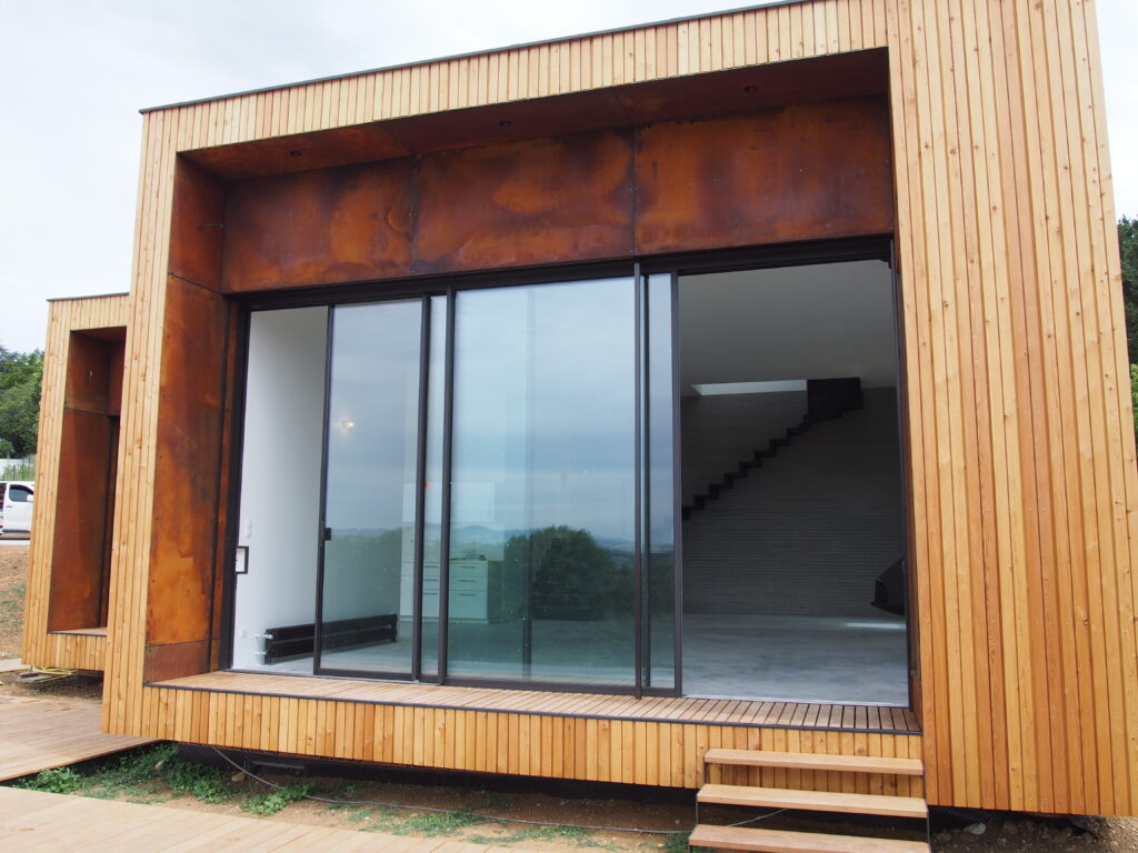 Maison contemporaine en ossature bois avec bardage en mélèze et acier corten.