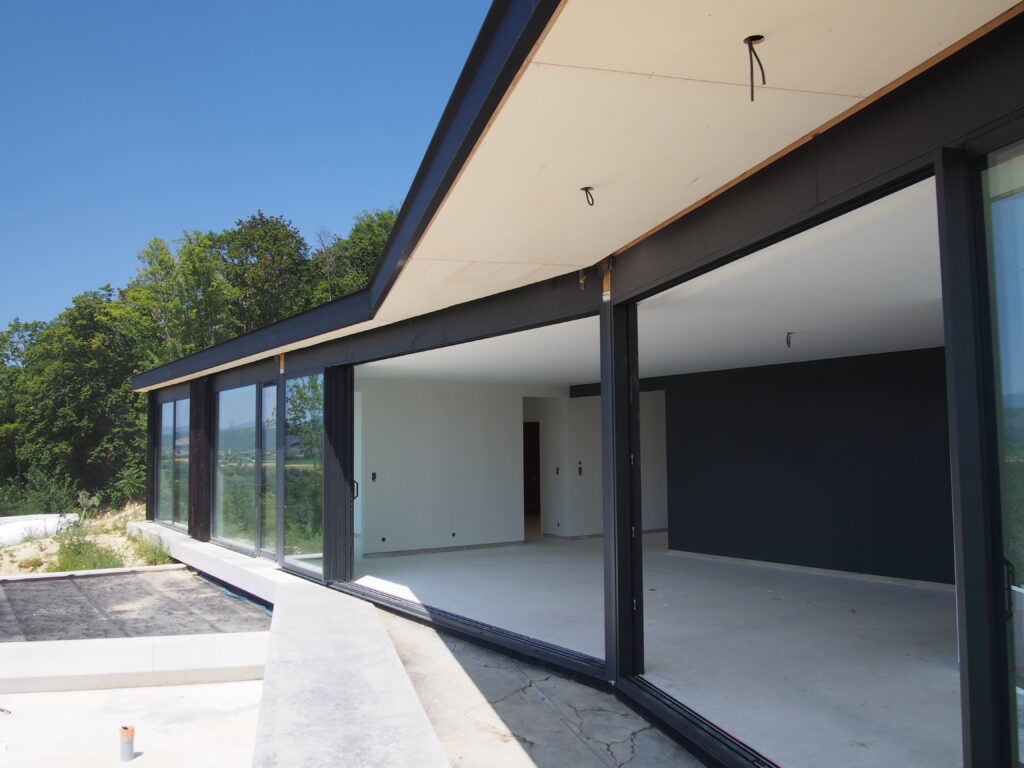 Maison ossature bois contemporaine avec bardage bois brûlé et toiture plate