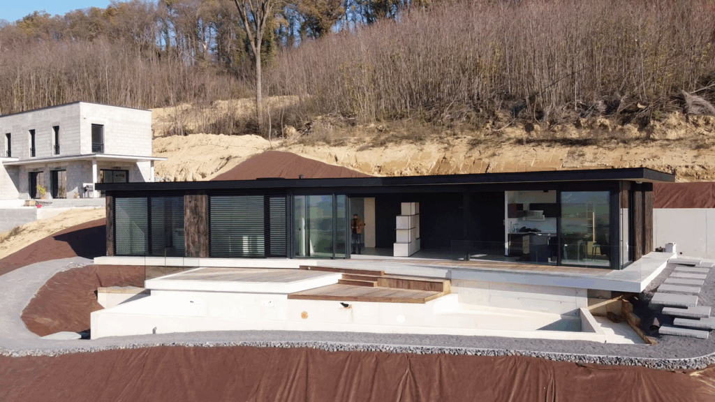 Maison moderne ossature bois avec bardage bois brûlé et toiture terrasse